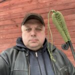 Алексей Васильев держит в руках готовую кованую кочергу